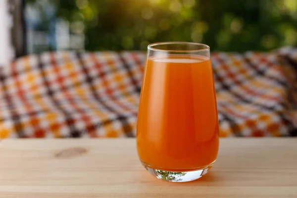 El vaso de jugo en un jardín. La mesa de madera — Foto de Stock