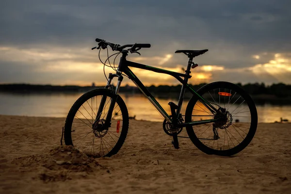Sylwetka sportowego roweru na plaży. Zachód słońca. — Zdjęcie stockowe