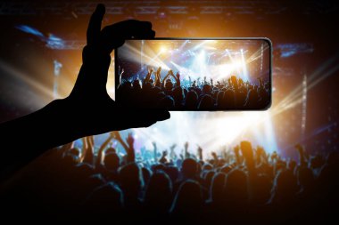 Konserdeki memnun insanlar, sahnenin renkli ışığı.