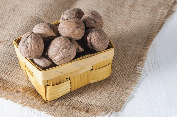 Nueces Una Canasta Mimbre Sobre Tela Saco Fondo Madera Blanca — Foto de Stock