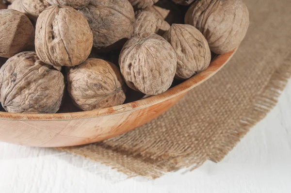 Muchas Nueces Yacen Tazón Cuenco Arpillera Fondo Madera Blanco — Foto de Stock