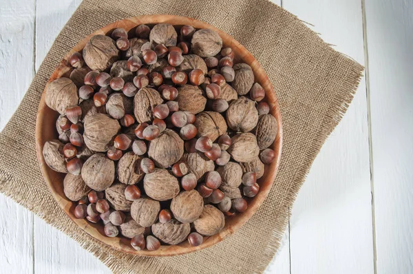 Surtido Nueces Avellanas Las Nueces Escudilla Arpillera Fondo Madera Blanca — Foto de Stock