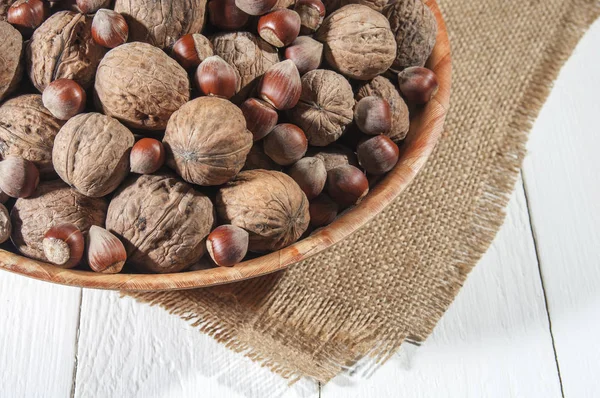 Muchas Nueces Tazón Cuenco Arpillera Fondo Madera Blanco — Foto de Stock