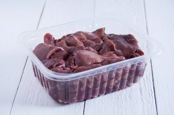 Beyaz ahşap t şeffaf bir kapta Çiğ tavuk ciğeri