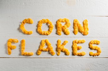 Mısır gevreğinden yapılmış sözler beyaz ahşap bir masanın üzerine serilmiş..