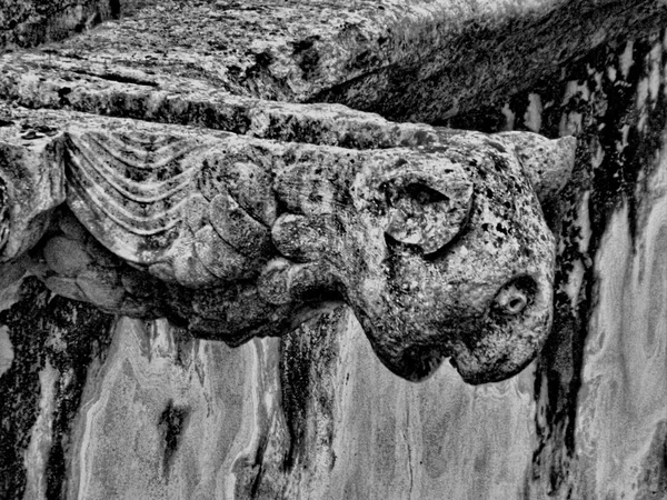 Gargoyle face carved in stone