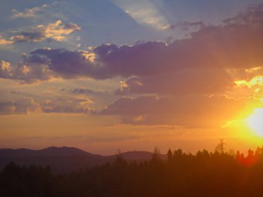 Mor ve sarı bulutlu gündoğumu kırsal ve dağ