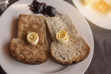 İki dilim tost, peynir ve çilek reçeli ile tepesinde ev yapımı kahvaltı.