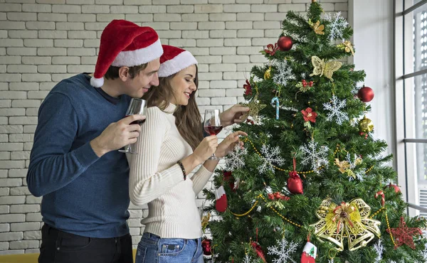Çift, karı koca, aile Noel kutluyor, kırmızı geniş bir cam tutarak, mutlu Noel ağacı bakarak, oturma odasında sıkışmış
