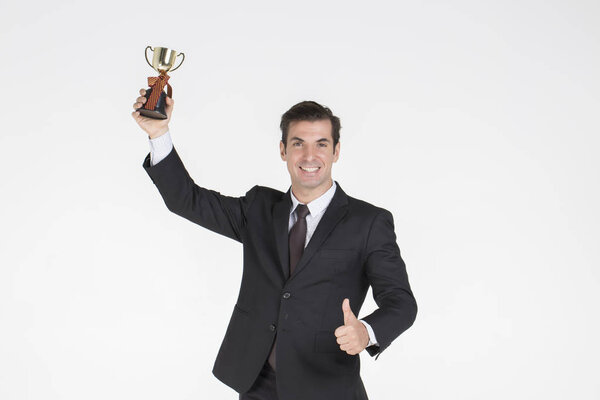 Successful Businessman handsome wearing a suit with tie Glad to win the business competition and thumb up hold gold words .