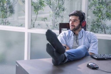 Smiling bearded Handsome men  put headphone listening song  relax at home clipart