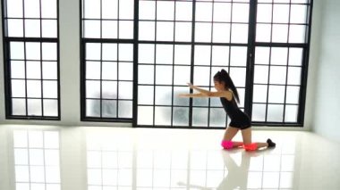 Uzun saçlı genç güzel kız dansçı mayo poz giyen ve stüdyoda duygusal çağdaş dans performans