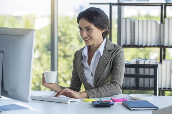 Güzel iş kadını e-postaları okuma ve sabah işten önce kahve içme