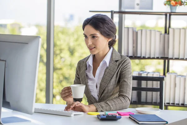 Güzel iş kadını e-postaları okuma ve sabah işten önce kahve içme