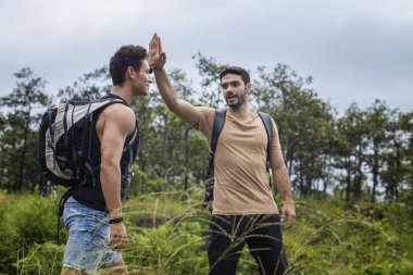 Genç erkek yürüyüşçüler beşlik çakıyor. 