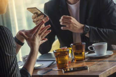 İletişim ve müzakere kavramı. İş adamları kahve dükkanında parasal analiz yapıyor ve parformans veri toplantısı hakkında pazarlık yapıyorlar