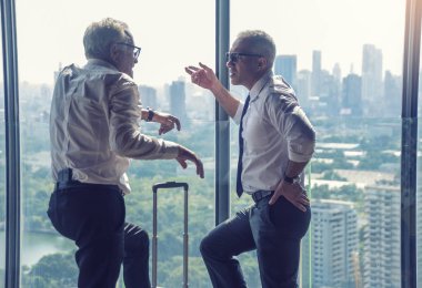 Kıdemli Başkan Yardımcısı şirket sahibi ve mimar ofiste çalışmayı tartışıyor.