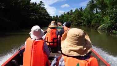 Tayland 'ın güneyindeki adanın güzelliğini görmek için tekneye binen turistler..