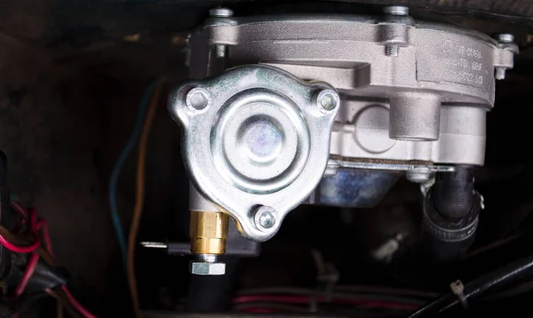 Reducer of a gas installation. Auto mechanic working on a car engine in a mechanics garage. Car repair and service stations.