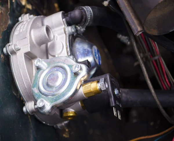 Reducer of a gas installation. Auto mechanic working on a car engine in a mechanics garage. Car repair and service stations.