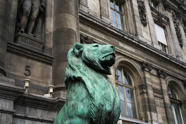 statue of a lion on the background of an architectural building in the old town