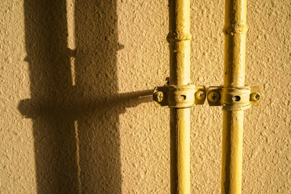 Zwei Gelbe Gasrohre Auf Einem Texturierten Gelben Hintergrund Schatten Von — Stockfoto