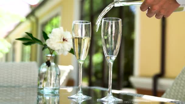 侍者往杯子里倒香槟 一个餐厅的桌子 夏天的阳台上有酒和杯子 — 图库视频影像