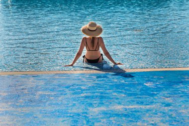 Güzel genç kız havuzda yıkanır. Spa tedavileri. Yaz tatili