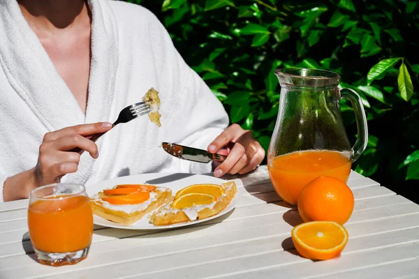 소녀가 집에서 오렌지 주스를 가운을 테라스에서 식사를 있으며 벨기에 나무로 — 스톡 사진