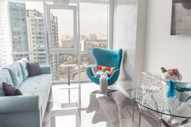 Açık renkli modern bir daire. Gri kanepe ve büyük panoramik pencereler avlu manzaralı Paris Haziran 2020