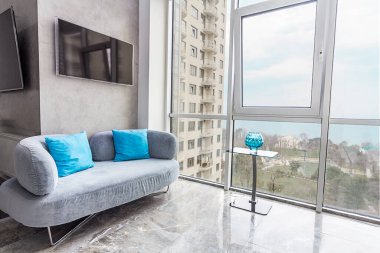 Açık renkli modern bir daire. Gri kanepe ve büyük panoramik pencereler avlu manzaralı Paris Haziran 2020