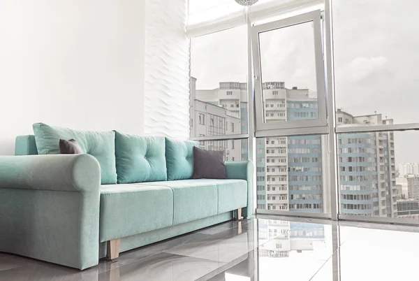 modern apartment in light colors. Green sofa and large panoramic windows overlooking the courtyard Paris june 2020