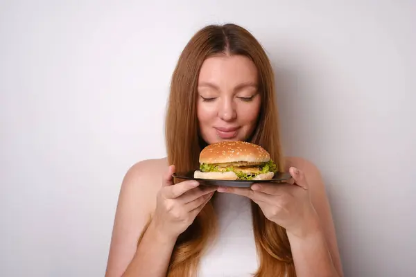 Porträt Einer Jungen Frau Die Einen Burger Auf Einem Teller Stockfoto