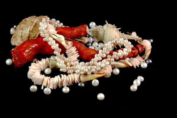 Colar, coral, pérolas e conchas sobre um fundo preto — Fotografia de Stock