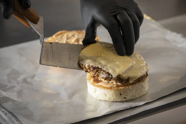 Chef Kok Met Spatel Putting Hamburger Met Kaas Brood — Stockfoto