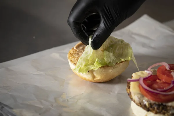 Chef Kok Met Handschoen Zet Sla Top Van Hamburger — Stockfoto