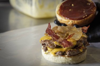 Şef hamburger üzerine koymak için ekmek yükselterek.