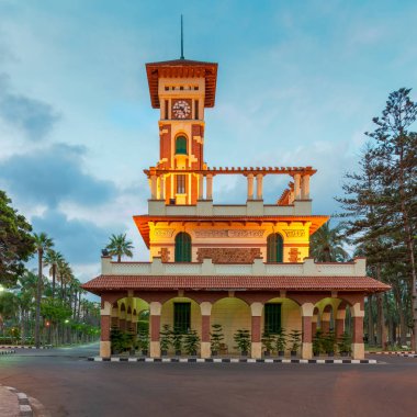 Cephe ile dekore edilmiş taş duvar, yeşil ahşap pencere panjur ve gündoğumu zaman, Montaza genel Park, Alexandria, Mısır, kırmızı kiremit Kanopiler Montaza genel Park'ta Saat Kulesi