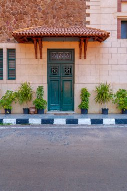 Kırmızı kiremit gölgelik yukarıdaki ile yeşil ahşap kapı ve pencere kepenkleri taş tuğla duvar, İskenderiye, Mısır ile Montaza genel Park'ta Saat Kulesi cephe