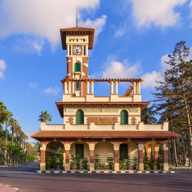 Cephe ile dekore edilmiş taş duvar, yeşil ahşap pencere panjur ve kırmızı kiremit Kanopiler gündoğumu, İskenderiye, Mısır sonra Montaza genel Park'ta Saat Kulesi