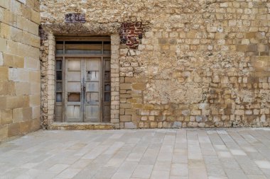 Taş tuğla duvar kırık yıpranmış ahşap kapı ile terk edilmiş