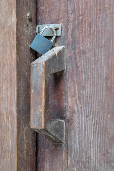 Ahşap bir kapı içinde bir asma kilit ile closeup ahşap bir yaşında mandal kilitli