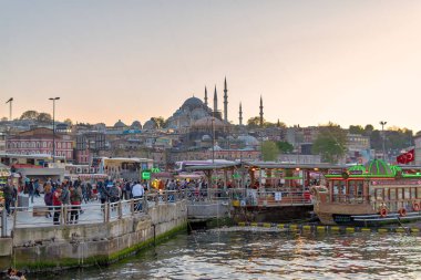 Istanbul, Türkiye - 25 Nisan 2017: Geleneksel lokanta sallanan porsiyon balık sandviç Rüstem Paşa Camii ve Süleymaniye Camii ile Eminönü bölgesinde arka plan, gün batımından önce tekne