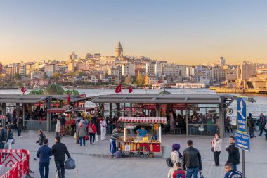 Eminönü Piazza yüzen deniz ürünleri restoranları ve şehir ile gün batımına görüntülemek bakan Galata Kulesi, Istanbul, Türkiye