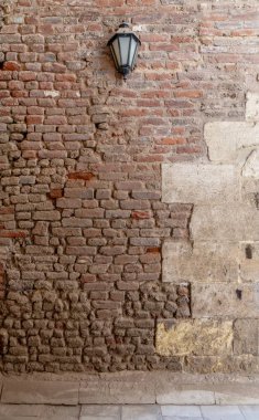 Grunge önden görünümü düzensiz kırmızı taş tuğla duvar ve bir fener, yıpranmış Ortaçağ Cairo, Mısır