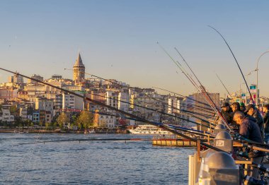 Istanbul, Türkiye - 25 Nisan 2017: arka planda, Eminönü İlçesi, Istanbul, Türkiye'de Galata Kulesi ile batımına, Haliç Galata Köprüsü'nde balık tutma yerel vatandaşların