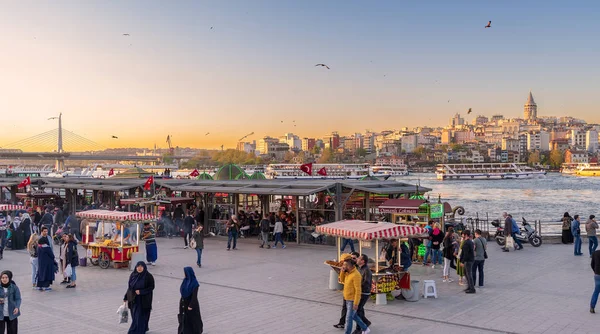 Istanbul, Türkiye - 25 Nisan 2017: Eminönü Piazza gıda arabaları satın ve deniz ürünleri restoranları, İstanbul 'un şehir manzaralı yüzen yerel vatandaşların Galata Kulesi bakan ile gün batımına