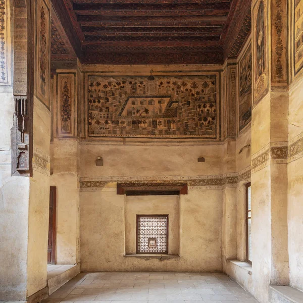 Cairo, Egypt - December 16 2018: Stone wall with wooden window (Mashrabiya) and mural depicting city of Medina at ottoman historic Beit El Set Waseela building (Waseela Hanem House), Old Cairo