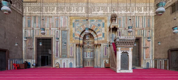 Cairo, Mısır - 8 Ocak 2019: Renkli süslü mermer duvara oyulmuş mihrap (niş) ve cami ve medrese (okul) Sultan Hassan'ın ahşap minber (Platform) ile
