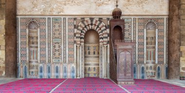 Colorful decorated marble wall with engraved Mihrab (niche) and wooden Minbar (Platform) at the public historical Mosque of Al Nasir Mohammad Ibn Qalawun, situated in the Citadel of Cairo in Egypt clipart